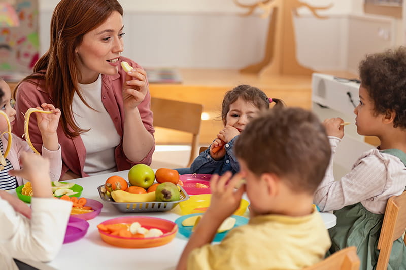 Kinder sitzen am Tisch und geniessen eine gesunde Malzeit.