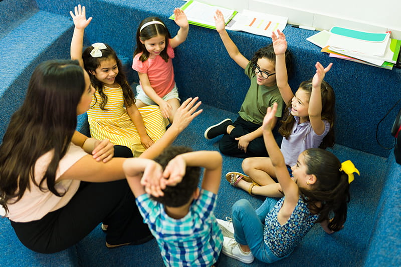 Eine Gruppe von Kindern stimmt ab. Die Kinder heben die Hände.